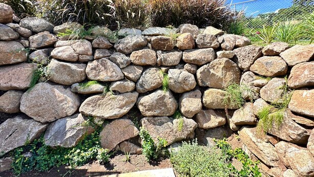 A stone wall with large rocks and some greenery. - Modern Grenada Studio with Mountain Views & Free Parking (Saint George's)