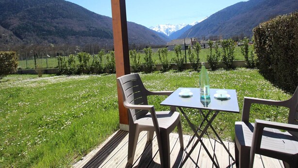 A patio with two chairs and a table, overlooking a mountainous landscape. - Modern 51m² Apartment in Luchon - 4 pers, Terrace, Parking (Bagnères-de-Luchon)
