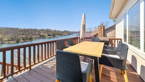 Une terrasse avec une table et des chaises donnant sur une rivière.