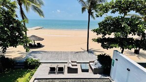 Zona de piscina con vista a una playa y al océano.