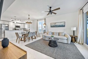 Uma sala de estar moderna com sofá, mesa de centro e área de refeições.