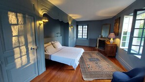 Un dormitorio con cama, cómoda, silla y alfombra.