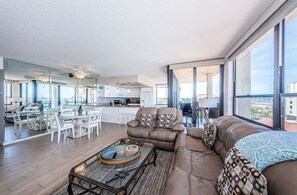 Un vaste espace de vie comprenant un canapé, une table basse et un ensemble de salle à manger.