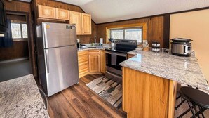 A kitchen with wooden cabinets, a stainless steel refrigerator, a stove, and a built-in oven. - Alpine Horn # 1 ~ Sauna & Close to Powderhorn! (Bessemer)