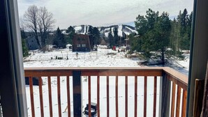 A snowy landscape with a wooden deck and a house in the background. - Alpine Horn # 1 ~ Sauna & Close to Powderhorn! (Bessemer)