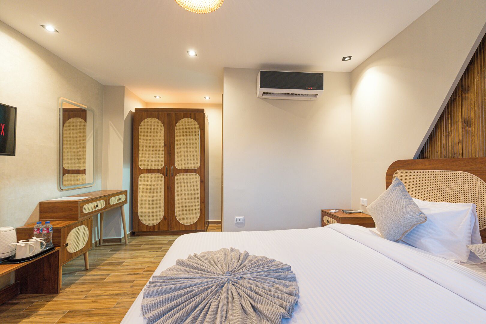 Una habitación de hotel con cama, mesita de noche, escritorio y armario.