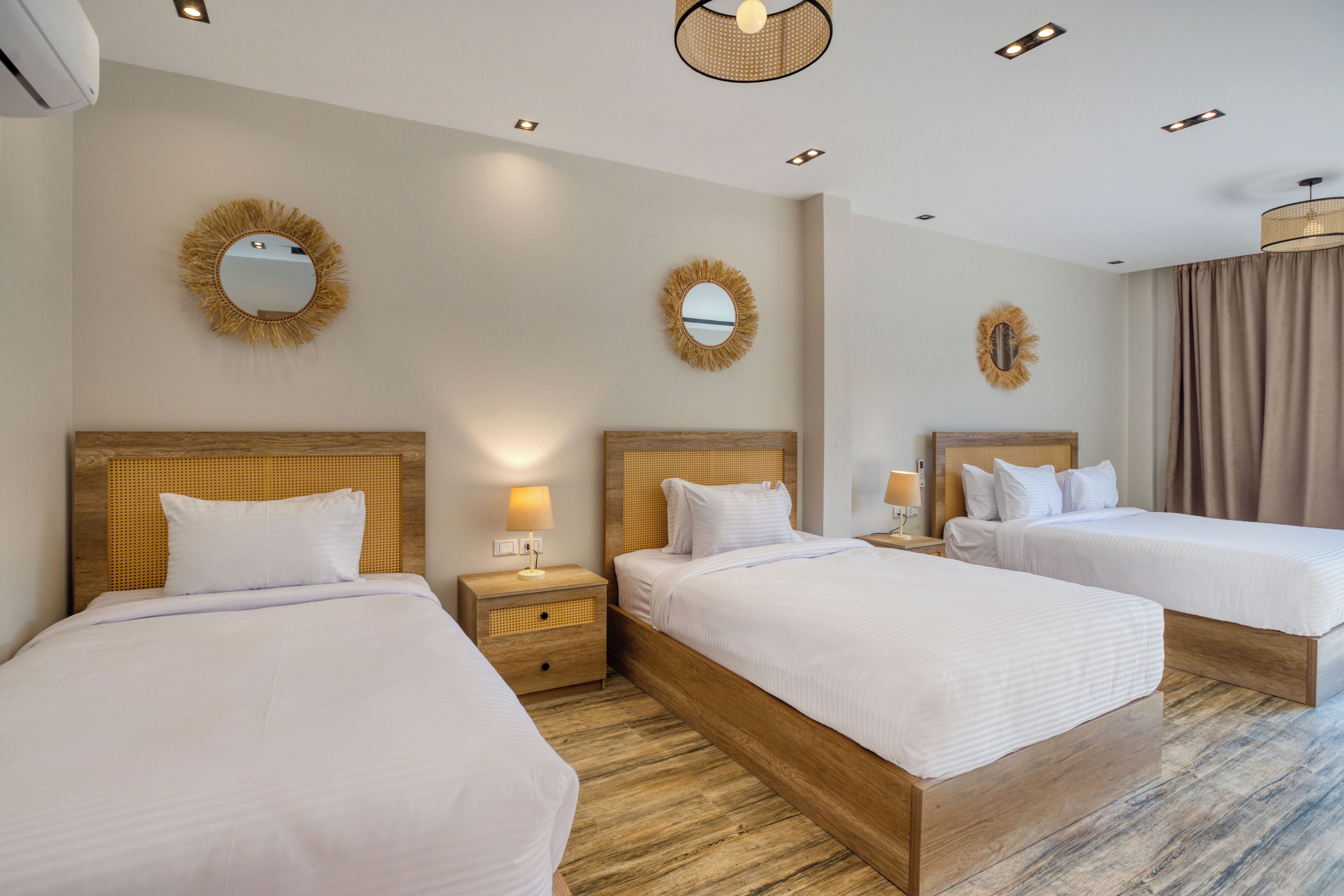A hotel room with two beds, wooden headboards, and a large mirror on the wall.