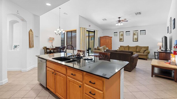 A spacious kitchen with a central island, wooden cabinets, and a built-in dishwasher. - Family Friendly  w/ Badminton | Goodyear Park (Goodyear)