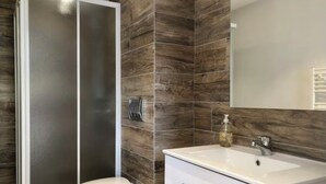 A bathroom with a toilet, a sink, and a mirror. - Villa located between sea and mountains (Conca)
