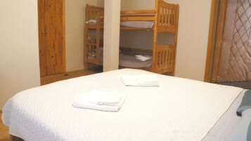 A single bed with white bedding and two neatly folded towels.