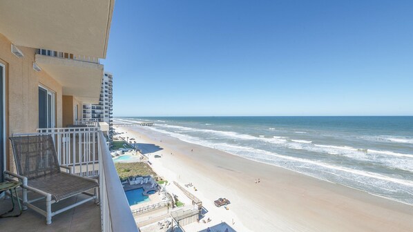 A balcony with a view of a beach and ocean.