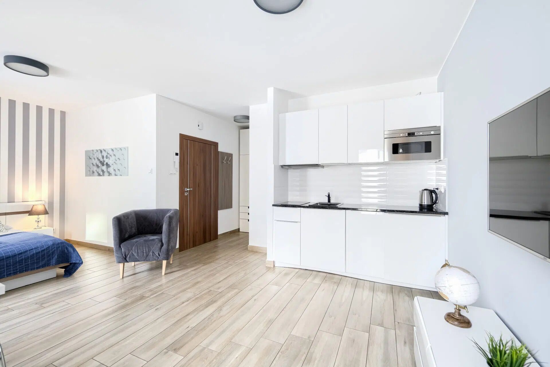 A modern apartment with a kitchen, a dining area, and a bedroom.
