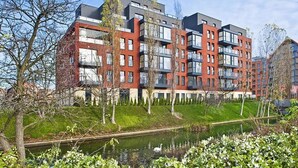 A modern apartment building with multiple balconies and a small canal in the foreground. - Hopfen by Little Heaven (Gdansk)