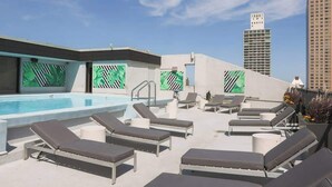 A rooftop pool area with lounge chairs, a pool, and a view of tall buildings. - Luxury Designer Penthouse 3803 | Pool | Gold Coast (Chicago)