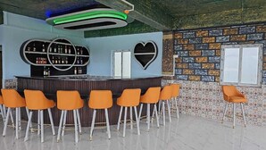 A bar area with a circular bar, orange chairs, and a heart-shaped decoration on the wall. - HOTEL KANGAROO (Ferrurgunj)