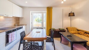 A compact living space with a kitchen, dining area, and seating area. - Terrace, charm & nature in the heart of Lannion (Lannion)