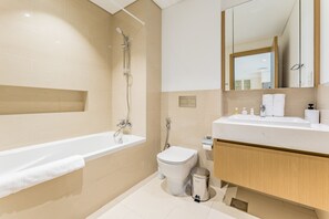 Ein modernes Badezimmer mit Badewanne, Toilette und Waschtisch.