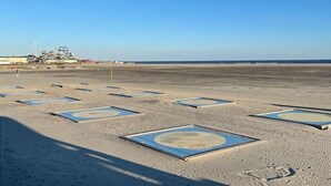 An empty beach with geometric patterns on the sand, a distant airplane, and a clear sky. - Southview Condominiums unit 203 Wildwood Newest Building! With a private pool (Wildwood)
