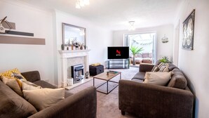 A living room with a fireplace, a television, and two sofas. - Colwell 4 Bedroom 3 Bathroom House (Derby)