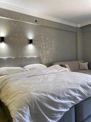 Ein Schlafzimmer mit einem großen Bett, einer Kopfteil und zwei Wandleuchten.