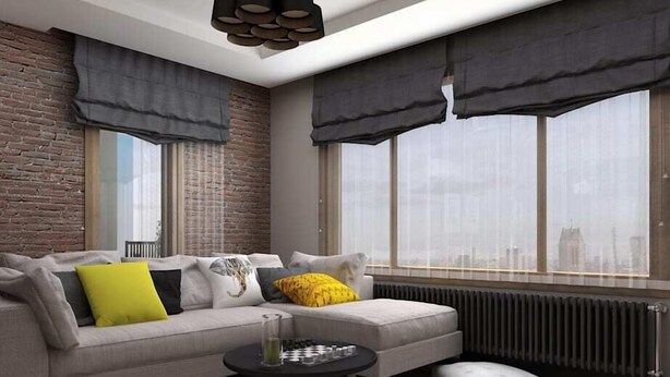 A modern living room with a grey sofa, a small black coffee table, and a view of the city through large windows.