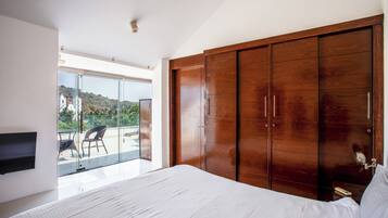 Ein Schlafzimmer mit einem großen Bett, einem Kleiderschrank und einem Balkon mit einem Stuhl.