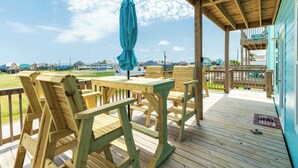 A wooden deck with outdoor furniture and a view of the ocean. - Spacious 3 Bedroom Surfside Home Near The Jetties (Surfside Beach)