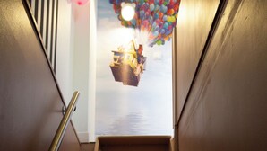 Una scala con ringhiera in metallo che conduce a una stanza con vista su una barca e palloncini.