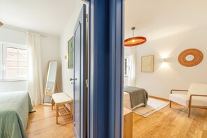 A bedroom with a bed, a chair, a desk, and a mirror. - Blue Tide - Two Bedroom Apartment (Cascais)