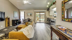 Un salon spacieux avec un long canapé, une table à manger et un coin cuisine à l’arrière-plan.