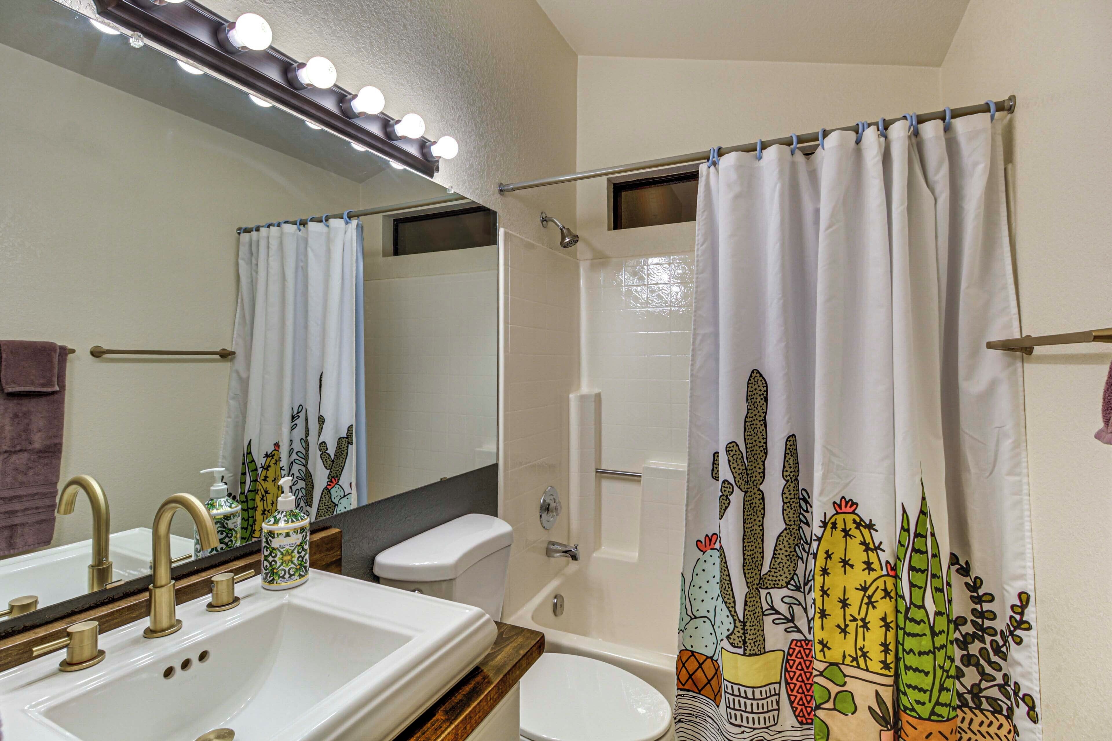 A bathroom with a sink, toilet, and shower.