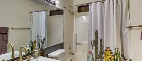 A bathroom with a sink, toilet, and shower.