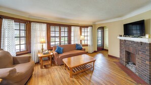 Sala de estar com sofá, poltrona, mesa de centro e lareira.