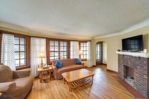 Una sala de estar con sofá, sillón, mesa de centro y chimenea.