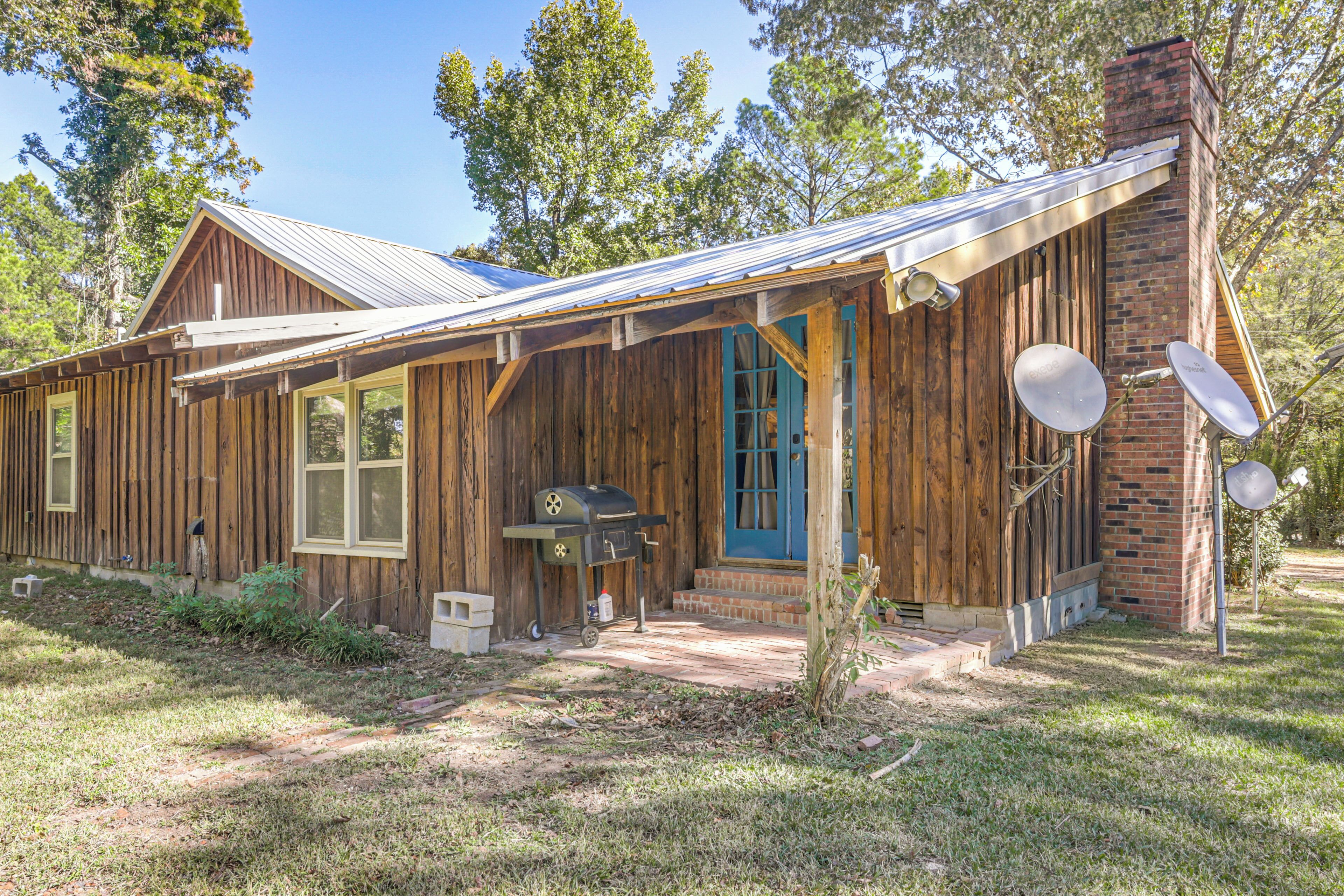 Une maison rustique en bois, avec un toit en métal, une porte bleue et des antennes paraboliques.