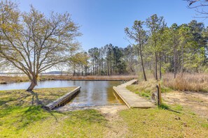 A wooden dock extending into a calm body of water, surrounded by grassy areas and trees. - Riverfront Haven: Converted Barn w/ Deck in Aurora (Aurora)