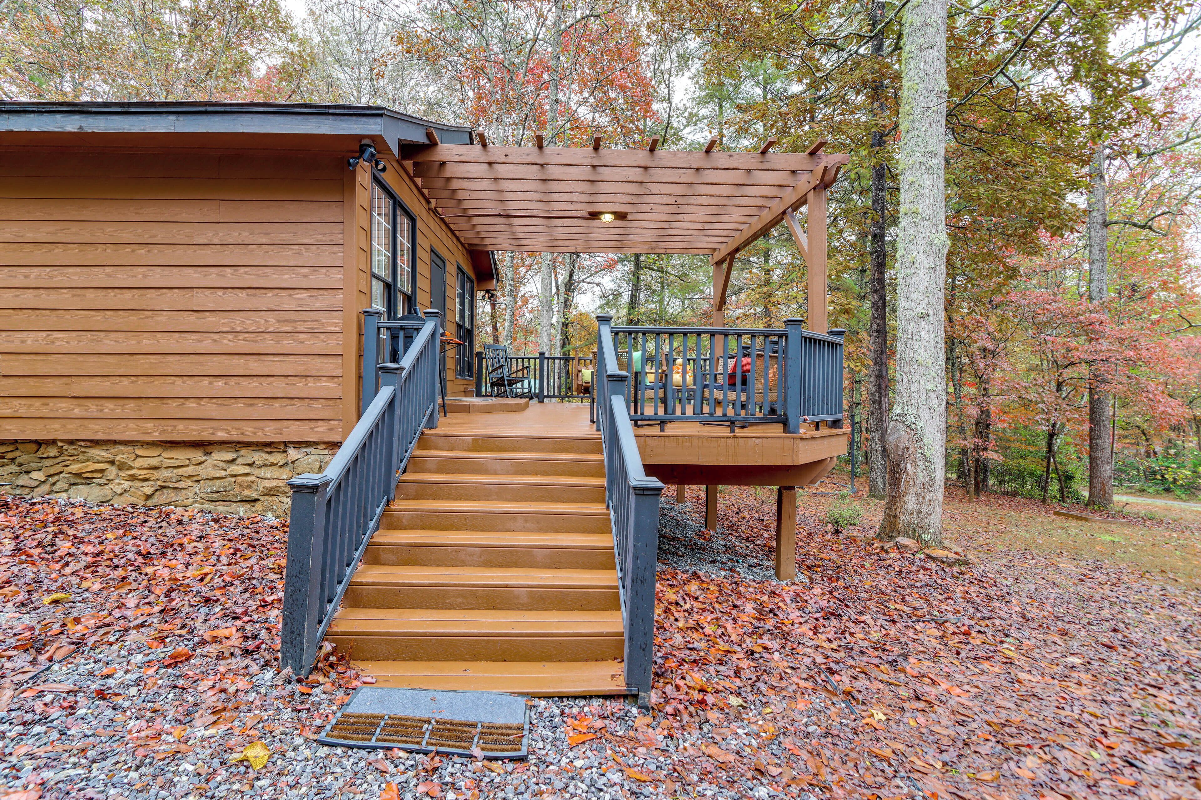 A wooden cabin with a covered porch and a staircase leading to a deck.