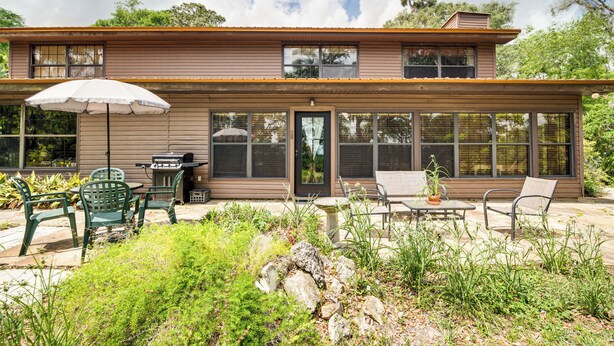 A two-story house with a patio area featuring outdoor furniture and a grill. - Lake Access + Private Patio: Sunny Inverness Apt! (Inverness)