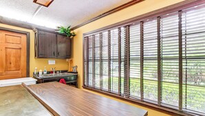 A kitchen with wooden cabinets, a sink, and a window with blinds. - Lake Access + Private Patio: Sunny Inverness Apt! (Inverness)
