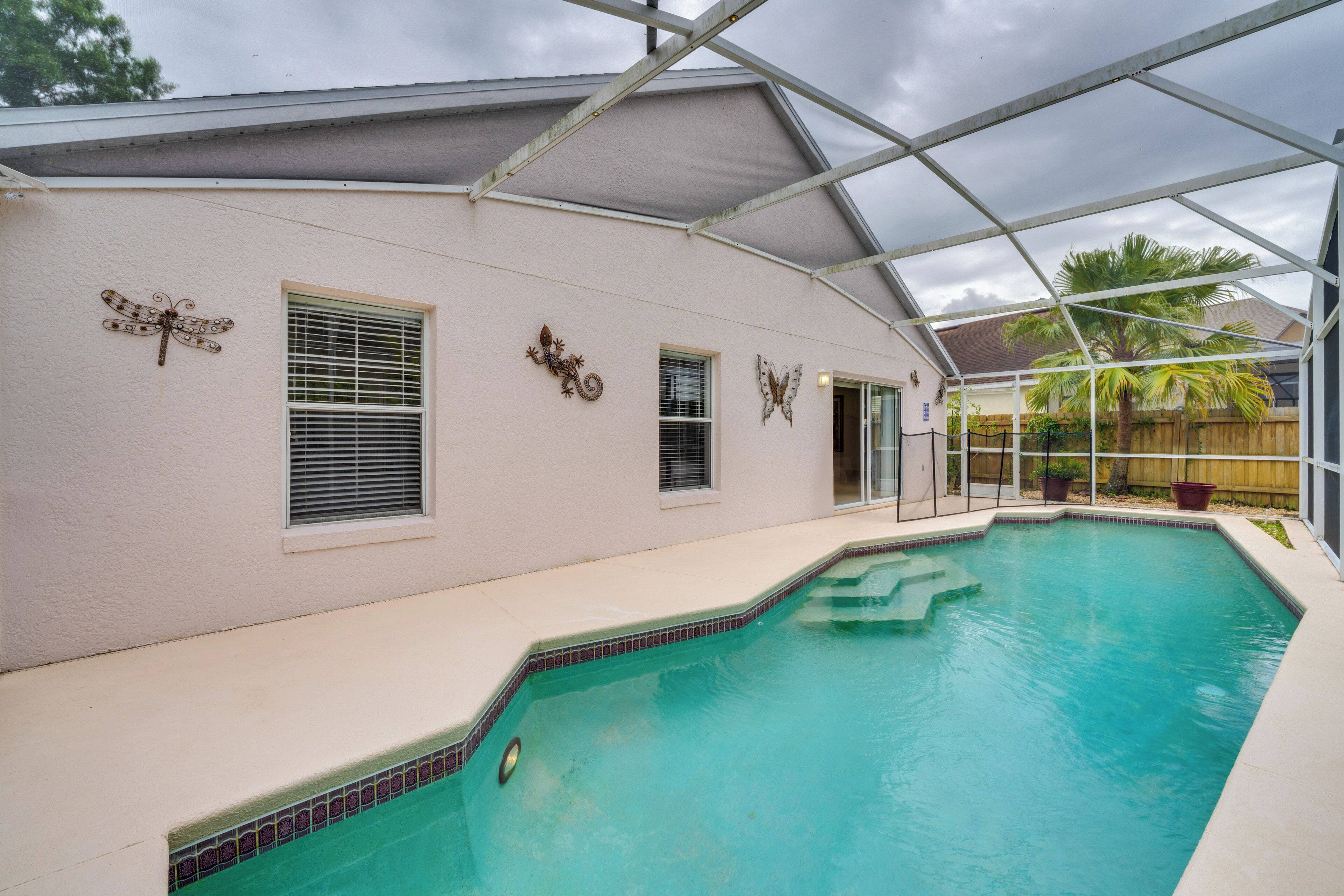Una piscina techada con fachada blanca y detalles decorativos en la pared.