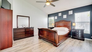 A bedroom with a wooden bed, a dresser, a nightstand, a ceiling fan, and a window with blinds. - 12 Mi to Disney: Family Home w/ Lanai in Davenport (Davenport)