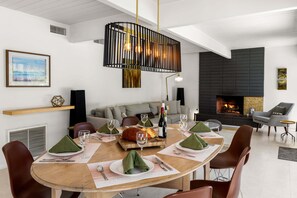 Un espace repas moderne avec une table ronde, des chaises et une cheminée.