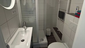 Une salle de bain moderne avec une douche à parois de verre, un lavabo et des toilettes.