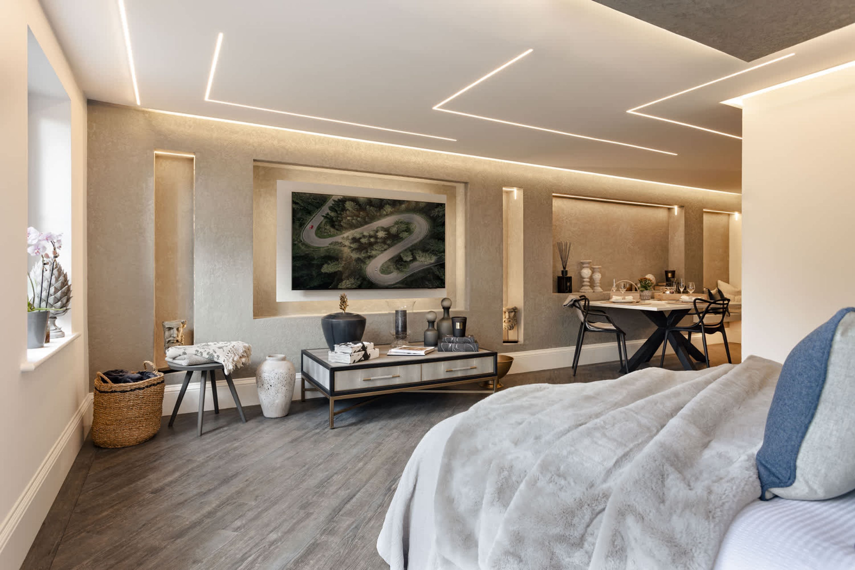 Un dormitorio moderno con una cama grande, un escritorio y una zona de comedor.