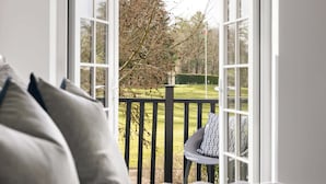 A room with a view of a green landscape through open windows. - The Sanctuary in Ullswater (Penrith)