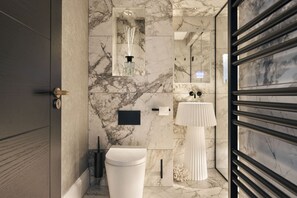 A modern bathroom with a marble floor, a white toilet, a black sink, and a mirror with a light fixture above it. - The Sanctuary in Ullswater (Penrith)