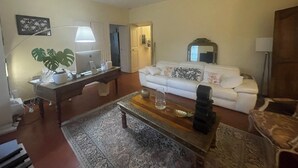 A living room with a white sofa, a coffee table, a lamp, and a plant. - Magnificent apartment with direct access to the Place des 9 Jets in CERET. (Céret)