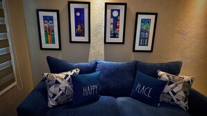 A blue sofa with geometric patterned pillows and framed artwork on the wall. - Privilege Apartment @ San Juan Convention Center with A/C, parking and Wi-Fi (San Juan)