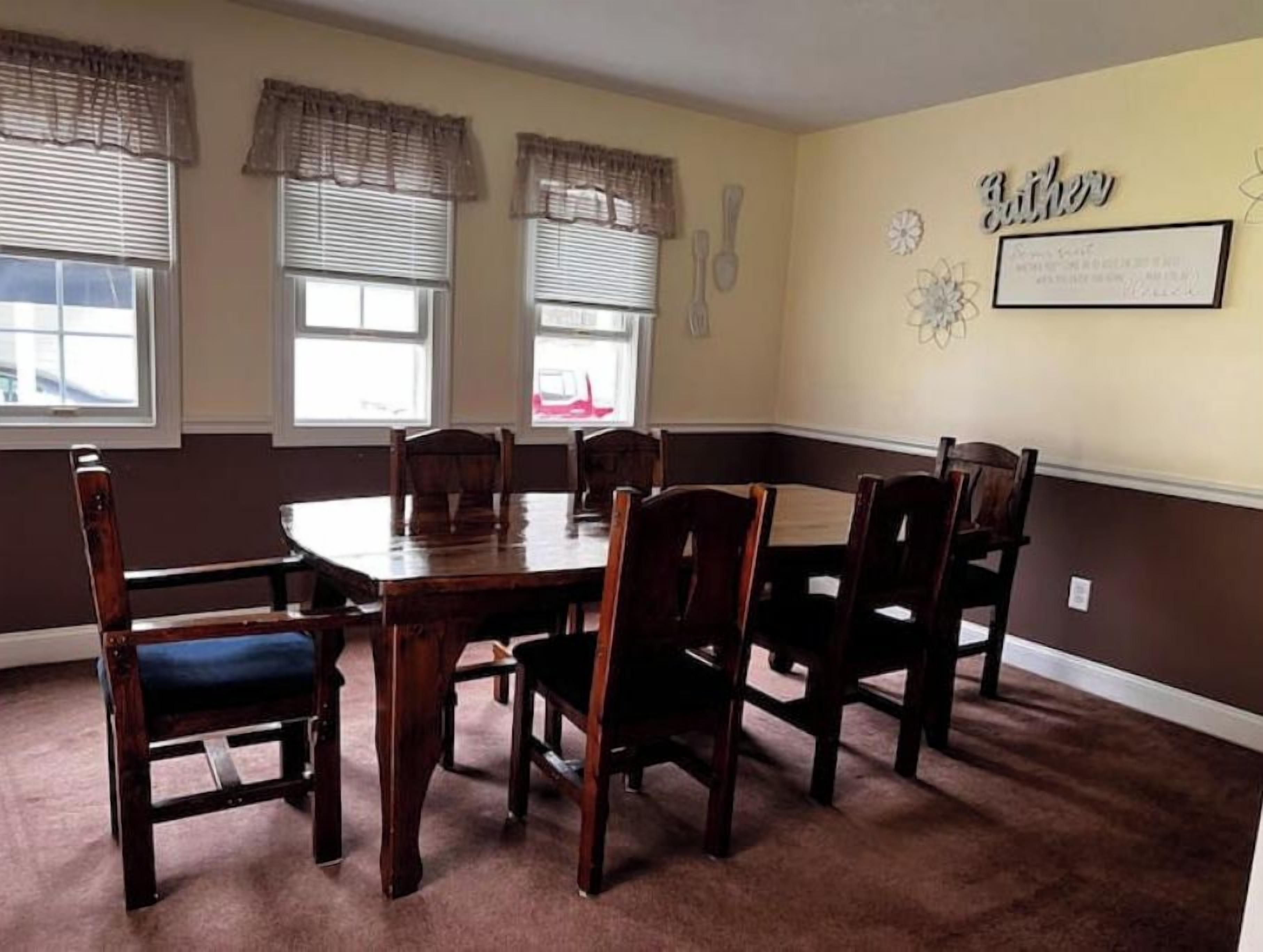 Une salle à manger avec une table en bois et six chaises, dont trois sont dotées de coussins bleus.
