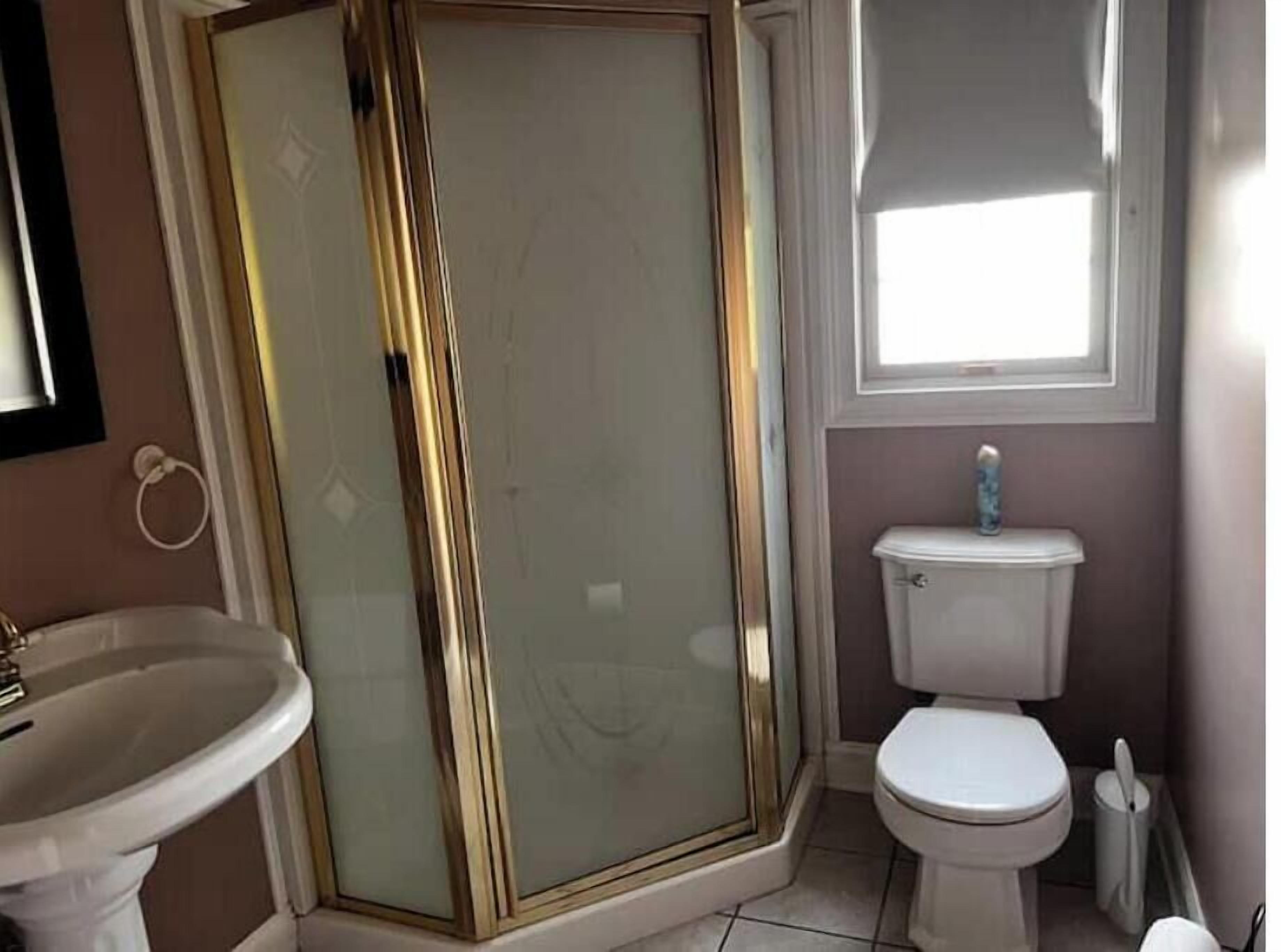 Ein Badezimmer mit Duschkabine, Toilette und Waschbecken.
